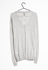 Ljust grå tröja i mjukt stickat material, med rund halsringning, långa ärmar och en lätt öppen rygg med sömdetalj.