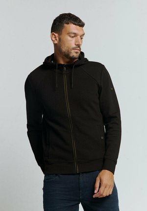 Black zip-up hoodie with a textured pattern, drawstring hood, and contrasting zipper. Features side pockets and ribbed cuffs.