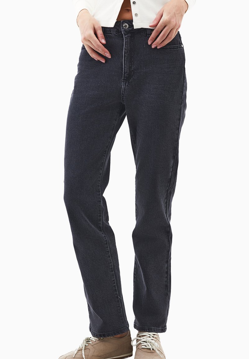 Jeans de mezclilla oscura con un corte recto, que cuentan con un cierre de botón, bolsillos frontales y un sutil detalle de costura a lo largo de las piernas.