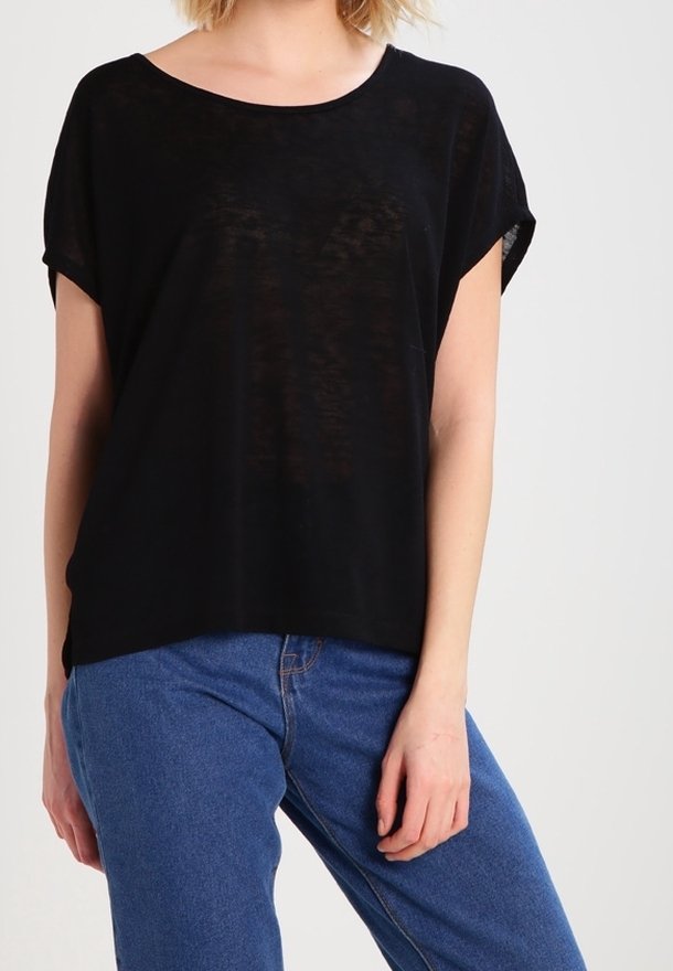 Černý krátký rukáv top s širokým výstřihem, vyrobený z lehké, mírně průhledné látky, spárován s modrými džíny s vysokým pasem.