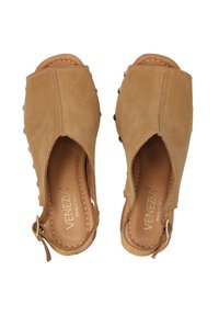 Tan suède open-toe schoenen met een uitsnijdingsontwerp, decoratieve knopen aan de zijkanten en een achterband die is vastgezet met een metalen sluiting.