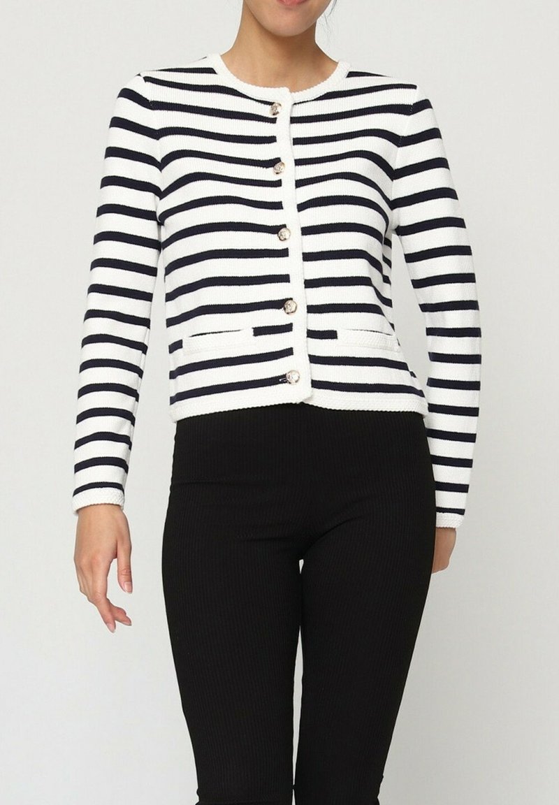 Gilet rayé en tissu tricoté bleu marine et blanc. Présente un col rond, une fermeture par boutons sur le devant et deux poches. Design texturé et ajusté.