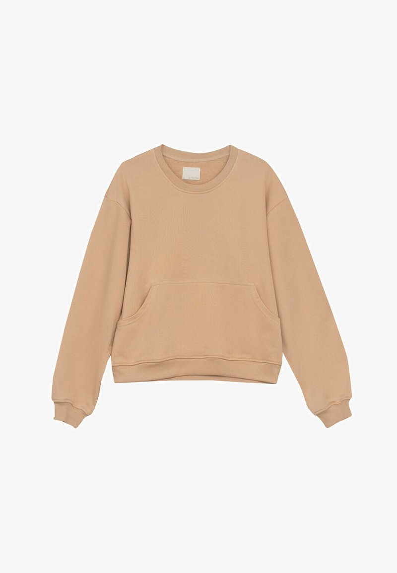 Beżowy sweter wykonany z miękkiego materiału, z okrągłym dekoltem, długimi rękawami i kieszenią z przodu. Krój jest luźny, z prążkowanymi mankietami.