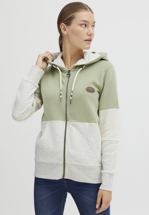 Felpa con cappuccio e zip caratterizzata da una parte superiore verde e una parte inferiore crema con texture a contrasto, cordini regolabili e una patch con logo.