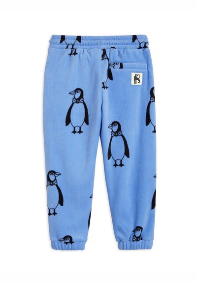 Pantaloni in pile blu con motivo ripetuto di pinguini neri, vita elastica e polsini elastici, con una piccola etichetta bianca sulla tasca.