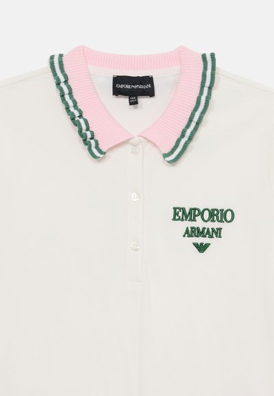 Bijela pamučna polo majica s rozim rebrastim ovratnikom na kojem se nalaze zeleni prugasti uzorci. Na prednjoj strani se nalazi izvezeni zeleni logo "Emporio Armani".