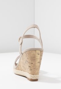 Beige sandály na klínu s korkovým podpatkem, se soft svrchním materiálem, nastavitelným páskem kolem kotníku a detaily z juty na platformě.