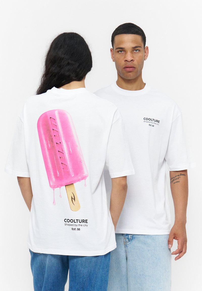 Deux personnes portant des t-shirts blancs ; l’une est de face avec un texte sur la poitrine, l’autre montre son dos avec un grand dessin de glace rose et un texte en dessous.