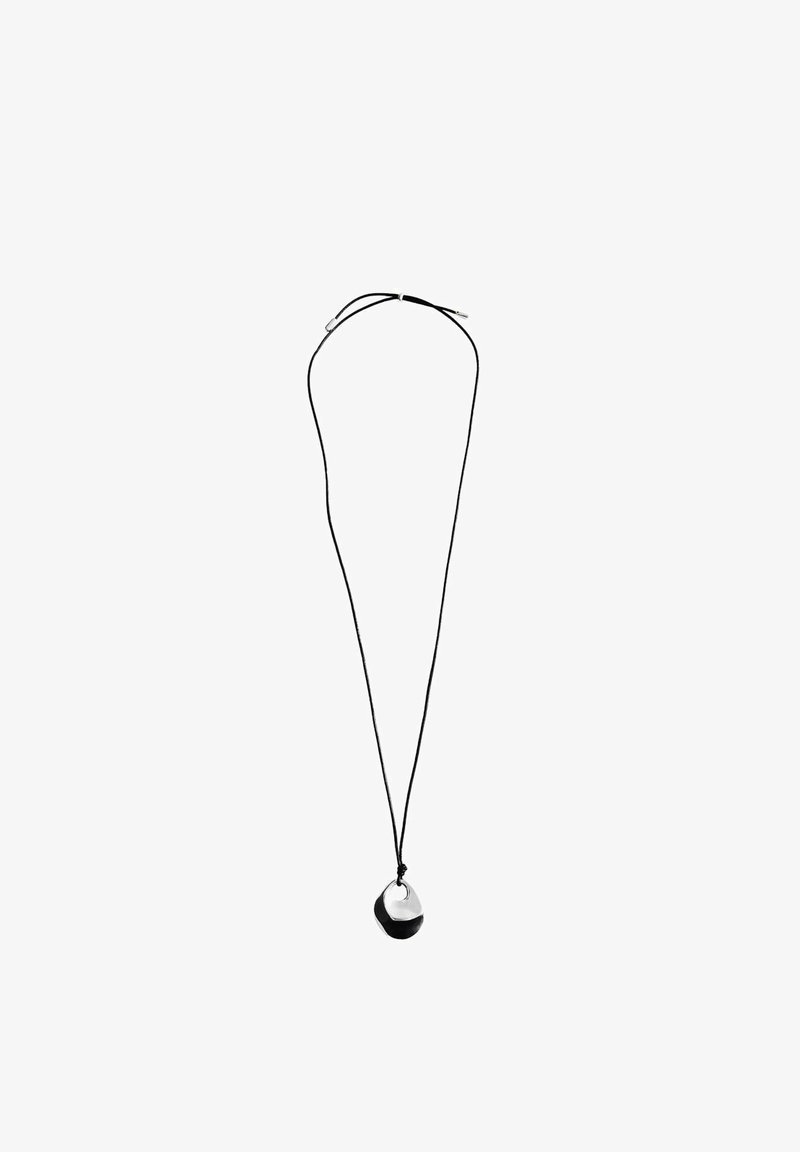 Collier à cordon noir avec un pendentif bicolore, doté d'un dessus argenté lisse et d'un dessous noir mat, créant un design moderne et minimaliste.
