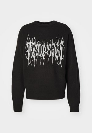 Sweater preto de malha com um design gráfico branco com bordas dentadas acentuadas ao longo do peito. Gola redonda e punhos canelados.
