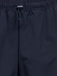Ceinture élastique bleu marine avec cordon noir réglable et bloqueur en plastique sur pantalon en tissu léger.