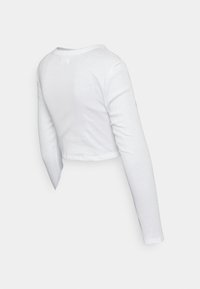Vit långärmad croppad skjorta visad från baksidan, gjord av ribbat tyg med rund halsringning.