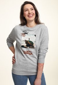 Sudadera gris hecha de un material suave, con un estampado gráfico que presenta texto multicolor y una imagen de una patineta junto a una escena oceánica.