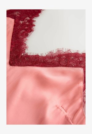 Roze satijnen stof met een rode bloemblaadjeskant aan de halslijn. Het kant heeft ingewikkelde patronen en gegolfde randen. Gladde textuur.