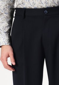 Pantaloni eleganți de marine, cu front plat, buzunare laterale și închidere cu button. Realizați dintr-un material neted, oferind o siluetă elegantă.