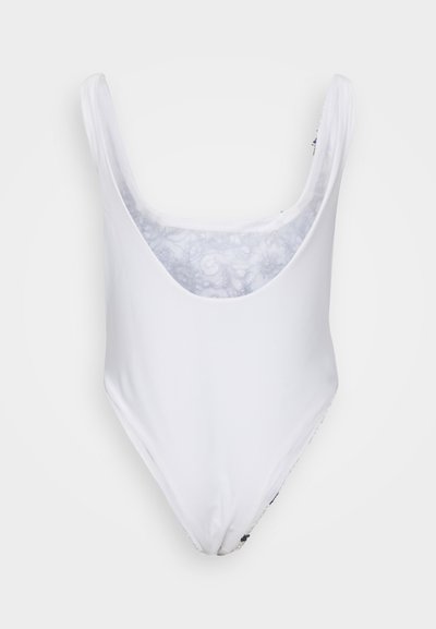 Biały jednoczęściowy strój kąpielowy z głębokim dekoltem w kształcie litery V, szerokimi ramiączkami i gładką fakturą. Wnętrze zdobi delikatny kwiatowy wzór.