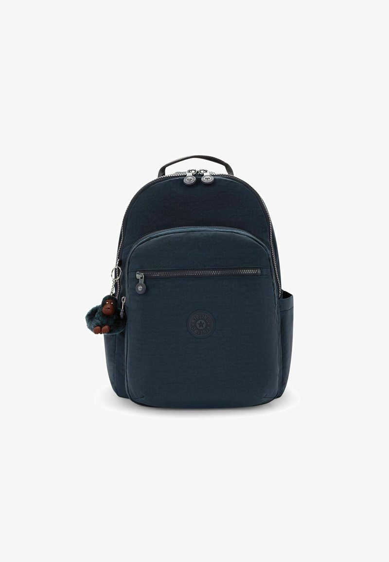 Mochila de nylon azul oscuro con un diseño redondeado, bolsillos con cremallera, superficie texturizada y un llavero de mono adjunto a la cremallera.