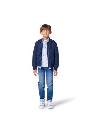 Veste de bombardier marine avec des poignets et un ourlet côtelés, associée à une chemise à rayures col, un jean bleu et des baskets blanches. Design simple, look décontracté.