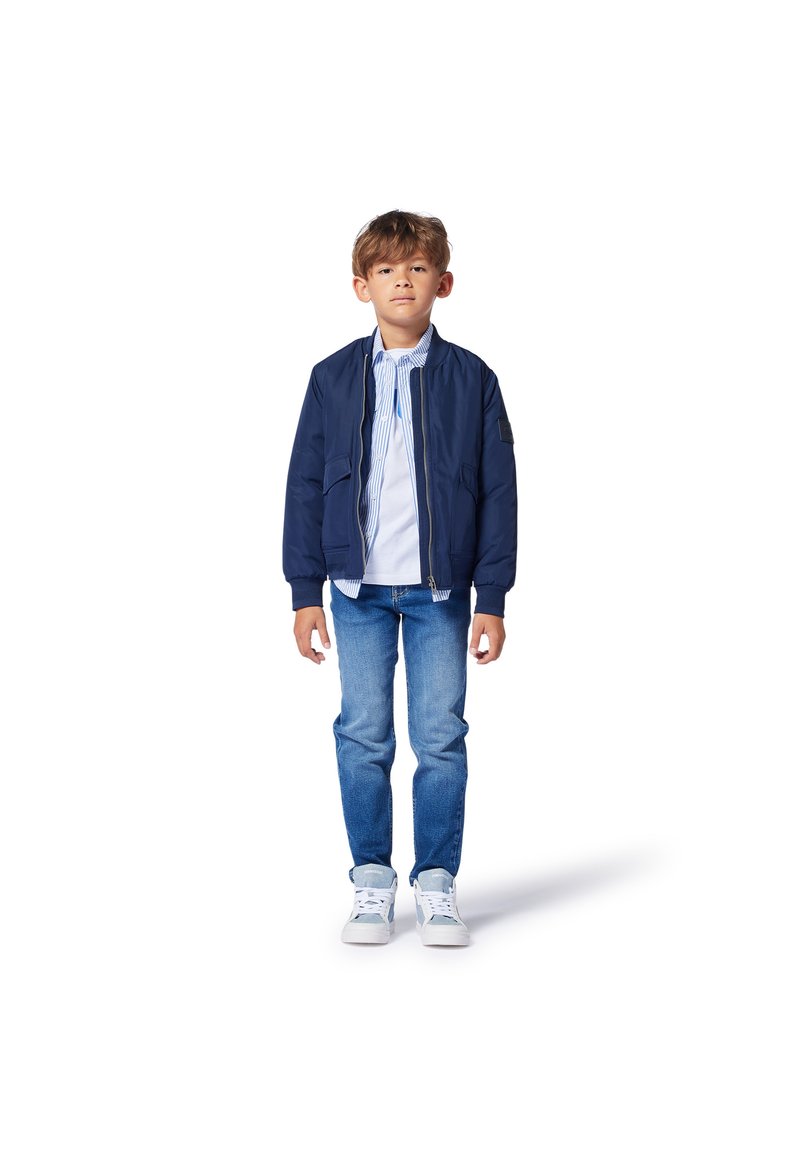 Marine bomberjack met ribbels bij de mouwen en onderrand, gecombineerd met een gestreept shirt met kraag, blauwe jeans en witte sneakers. Eenvoudig ontwerp, casual uitstraling.