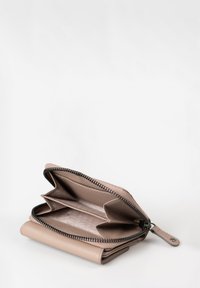 Portafoglio beige con zip, dotato di due scomparti, esterno testurizzato, interno liscio e dettagli in zip neri. Design compatto e pratico.