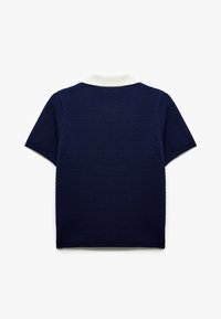 Marinblå kortärmad polo med ett texturerat, vävt tyg. Har en vit krage och en rak fåll, vilket ger en klassisk design.