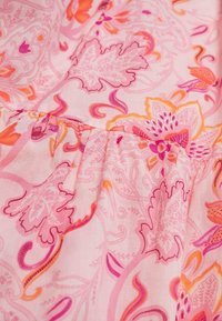 Rosa stof med blomster- og paisley-mønstre i nuancer af rosa, orange og lilla. Designet har en subtil tekstur og plisserede detaljer.