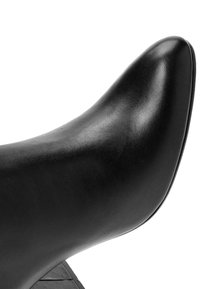 Zapato de tacón alto de cuero negro con punta afilada y textura suave, con un tacón en forma de cono y un diseño elegante y minimalista.