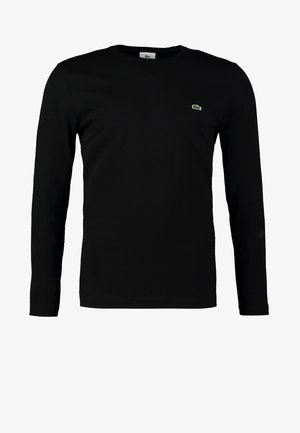 T-shirt à manches longues noir en coton. Présente un logo brodé vert sur la poitrine. Design simple et ajusté avec un col rond.