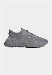 Sneaker sportive grigie con una parte superiore in mesh testurizzato e rifiniture in suede liscio. Suola chunky con un design ondulato. Lacci dello stesso colore grigio.