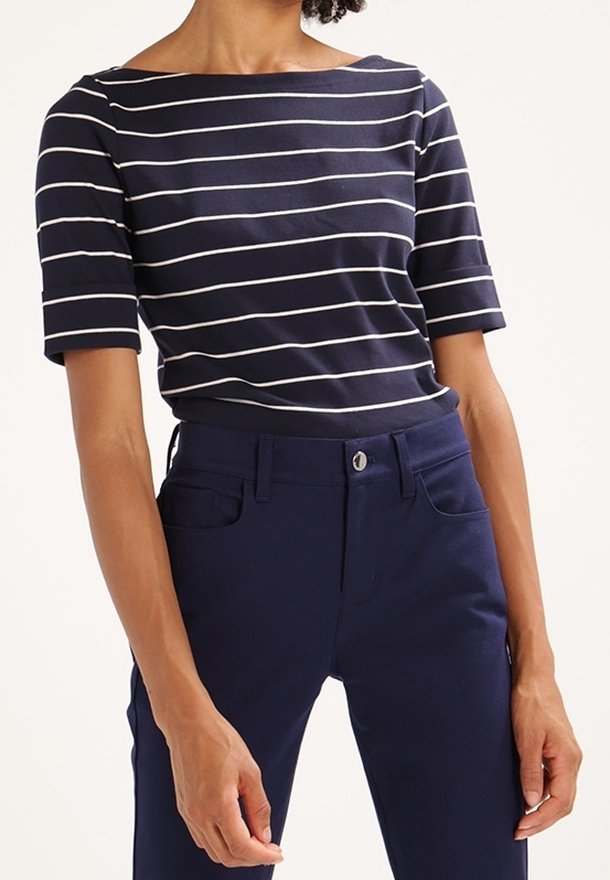 Marinblå och vit randig kortärmad topp med båturringning, i kombination med mörk marinblå byxor med framknapp och sidofickor.