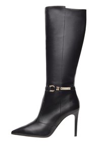 Stivale in pelle nera fino al ginocchio con punta affilata, tacco a spillo e dettaglio in oro sulla cinghia alla caviglia; texture liscia, design elegante.