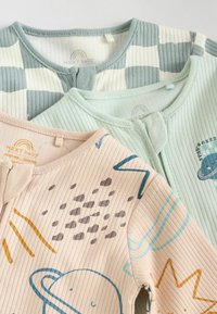 Tre babykläder: en mintgrön, en blek persika med planetdesign och en randig i ljusgrå och vit. Alla har ribbad textur.