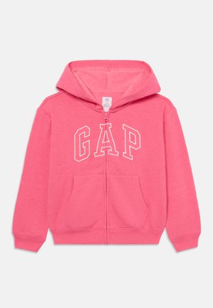 Sweatshirt rosa com capuz, apresentando um fecho de zipper, logótipo "GAP" em branco e dois bolsos frontais. Feito de um tecido macio e texturizado.
