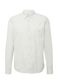 Chemise blanche en lin à manches longues avec col à boutonnière, poche avant et un tissu légèrement texturé. Six boutons sur le devant et ourlet arrondi.
