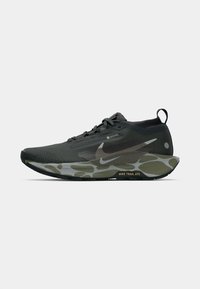 Melnās un olīvu zaļās Nike taku skriešanas kurpes ar Gore-Tex augšdaļu, auklu aizdari, cilpu un kamuflāžas raksta putem ainām.