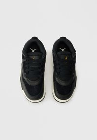 Ζευγάρι μαύρων και λευκών αθλητικών παπουτσιών με κορδόνια, με λογότυπο στη γλώσσα και στο εσωτερικό, απεικονιζόμενο από πάνω σε απλό φόντο.