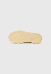 Rubber shoe sole with a textured, patterned surface. Beige color with geometric tread design for traction and durability.