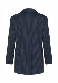 Sötét tengerészkék zakó fehér tűcsíkokkal, egysoros gombolással, bevágott gallérral és gombos mandzsettákkal. Sima szövet textúra, testre szabott szabás.