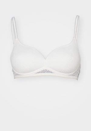 Reggiseno bianco con un motivo testurizzato e ondulato. Presenta spalline regolabili e una fascia liscia sottolineata. Materiale morbido con un design senza cuciture.