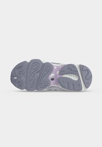 Σόλα αθλητικού παπουτσιού New Balance που δείχνει μοτίβα πέλματος σε γκρι και μωβ με τη σήμανση "new balance" στην περιοχή της πτέρνας.