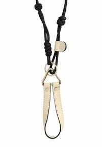 Bracelet en cuir crème avec bordure noire, mettant en valeur un anneau métallique doré, fixé à une paracorde noire avec des nœuds.