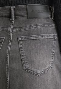 Gray denim skirt with a high waist, featuring a leather brand patch and two back pockets with a subtle stitching pattern.