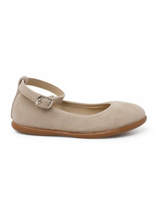 Beige suede ballet flat with rounded toe, adjustable ankle strap, and flexible brown rubber sole. Smooth texture, minimalist design.