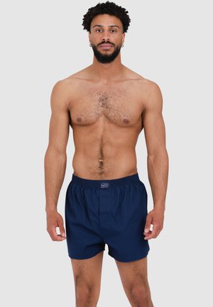 Navy blue boxer shorts made of lightweight fabric, featuring an elastic waistband and a simple design without patterns or accents.