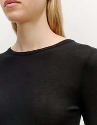 Zwarte geribbelde longsleeve top met een ronde hals. De stof lijkt rekbaar met een subtiele glans en past nauwsluitend op het lichaam.