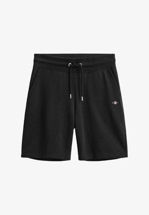 Schwarze Freizeithose mit Kordelzugbund, Seitentaschen und kleinem GANT-Logo am rechten Oberschenkel.