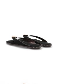 Chanclas negras con una plantilla suave, que presentan tiras cruzadas y un acento metálico en la punta. Textura suave con un diseño plano.