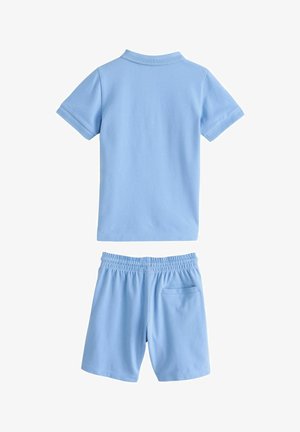 Gaiši zilas kokvilnas divdaļīgs komplekts, kas sastāv no īsu piedurkņu polo krekla un īsu biksēm ar elastīgu jostu un aizmugures kabatu. Gluda tekstūra.