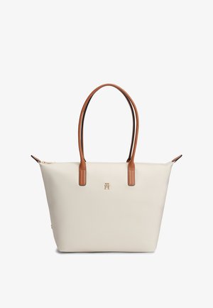 Κρεμ ορθογώνια τσάντα ώμου με διπλές καφέ λαβές και μικρό χρυσό λογότυπο «TH» στο κέντρο της μπροστινής πλευράς.