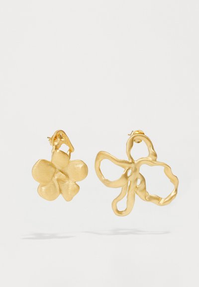 Boucles d'oreilles en or présentant deux designs : une fleur texturée avec des pétales arrondis et une forme de papillon abstraite et fluide. Les deux arborent une finition mate.